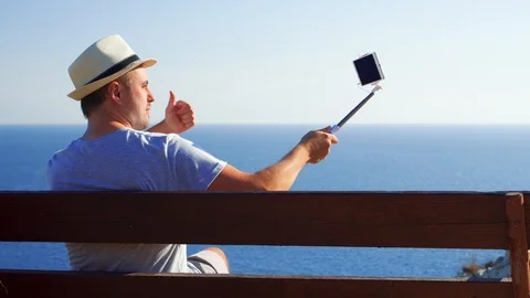 Young man relax on bench at edge of cliff do selfie on mobile phone. Man Video stock 98609688
