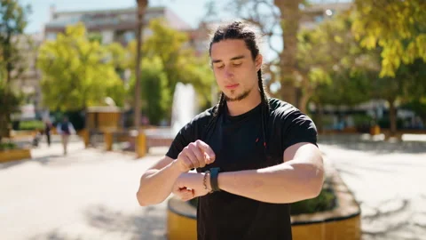 Young man with relaxed expression looking stopwatch at park Stock-Footage 171067025