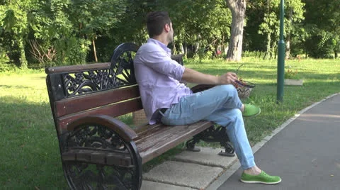 Young man  is relaxes in the park Vídeos de archivo 25552860