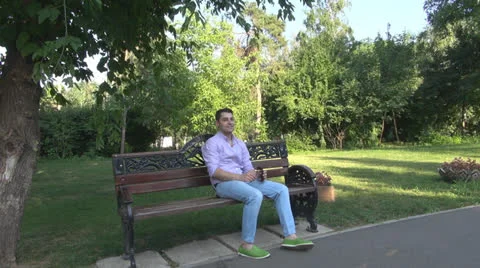 Young man  is relaxes in the park Vídeos de archivo 25553345