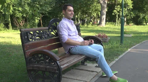 Young man  is relaxes in the park Vídeos de archivo 25553524