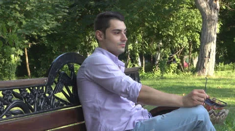 Young man  is relaxes in the park Vídeos de archivo 25554456
