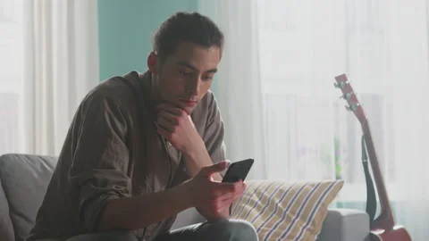 Young Man Relaxes Using Smartphone Stock Footage 156743720