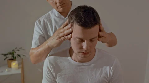 Young man relaxing during professional head massage in SPA salon. Strong masseur Stock Footage 170545645