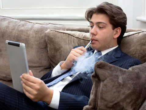 Young man relaxing with an e-cigarette Stock Photos