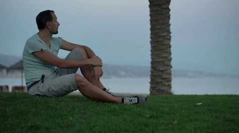 Young man relaxing on the grass close to the beach HD Vídeo Stock 43401268