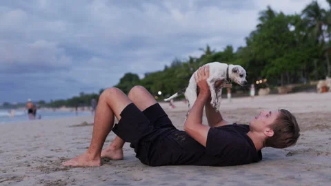 A young man relaxing on a sandy beach at sunset Stock Footage 300074127