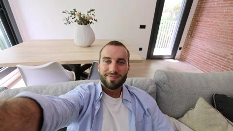 Young man relaxing on sofa making a video call Stock Footage 335588581