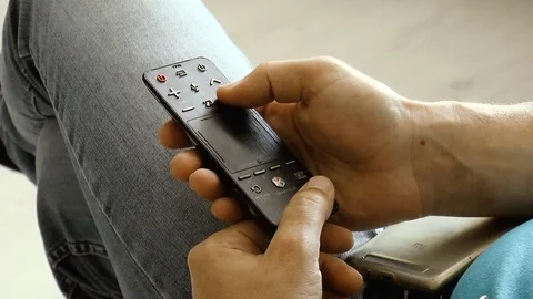 Young man with remote control from TV in hands Stock Footage 78306762