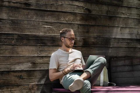 Young man remote worker web developer using laptop, working online at outdoor 写真素材
