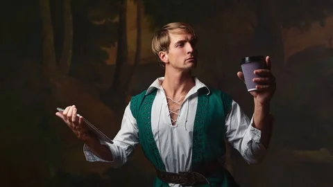 Young man in Renaissance style uses gadgets. funny duet of medieval style and Stock Footage 128992963