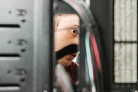 Young man repairs a computer system unit, changes parts, video card and hard Stock Photos