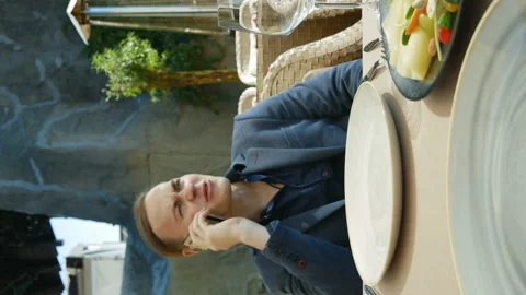 Young man in a restaurant talking on the phone. vertical video Stock Footage 136776868