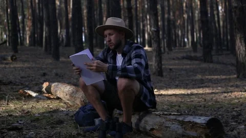 Young man resting and checking the map while hiking in the mountains or forest Stock Footage 150255828