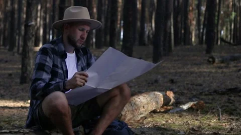Young man resting and checking the map while hiking in the mountains or forest Stock-Footage 150255847