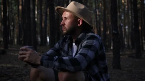 Young man resting and drinking hot tea while hiking in the mountains Stock Footage 150256101