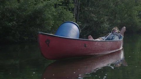 Young man resting in a canoe on the river 動画素材 76737095