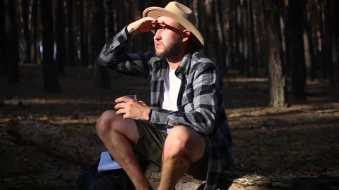 Young man resting on a log while hiking in the mountains or forest at sunset. Stock-Footage 150255446