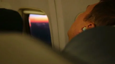 Young man resting on the plane during the flight. He sleeps in the headphones Video stock 67763183