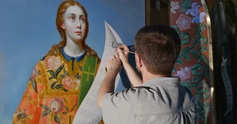 Young Man, a Restorator, Paints Something on an Icon of Saint Mary Looking Stock Footage 52823022