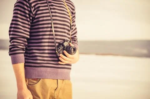 Young man with retro photo camera outdoor hipster lifestyle with nature on ba Stock Photos