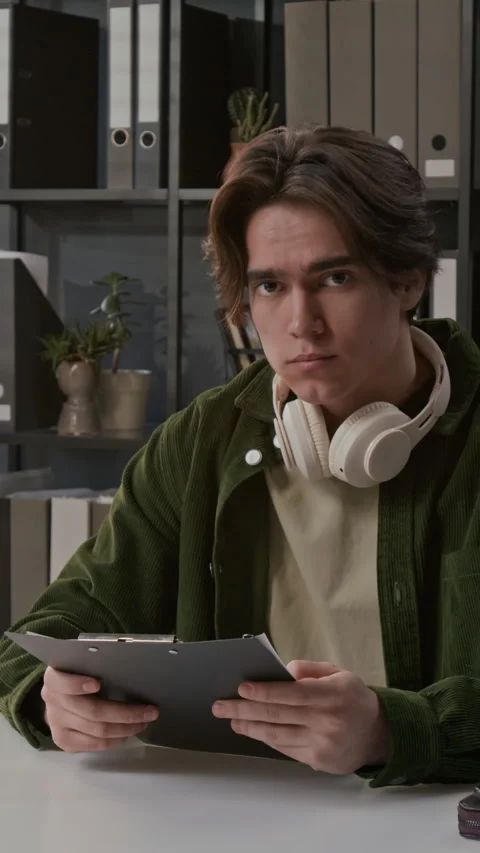 Young Man Reviewing Documents Wearing Headphones Stock Footage 330962652