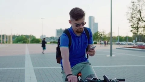 Young man rides a bicycle and using smartphone Stock Footage 79071828