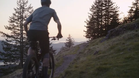 Young man rides his mountain bike into the sunset - Orcas Island Stock Footage 89021377