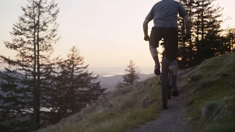 Young man rides his mountain bike into the sunset - Orcas Island Stock Footage 89021420