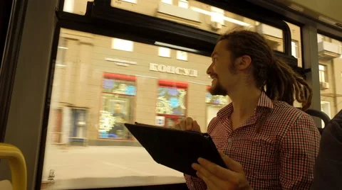 A young man riding a bus with tablet Stock Footage 65372643