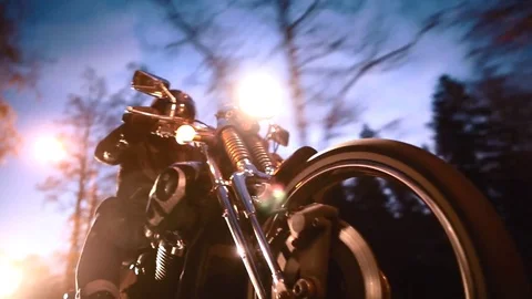A young man riding a chopper on a road in the evening Видео 73543559