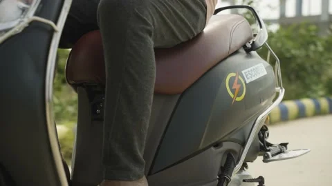 Young man riding electric or ev scooter on road - concept of zero emission Stock Footage 197745791