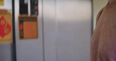 Young Man Riding Elevator Down Pushing Button to Floor One, 4K Stock Footage 65138877