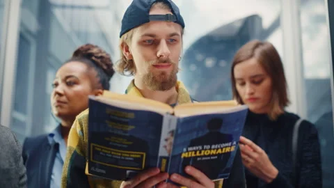 Young Man Riding Elevator Reading Book 스톡 동영상 167836997