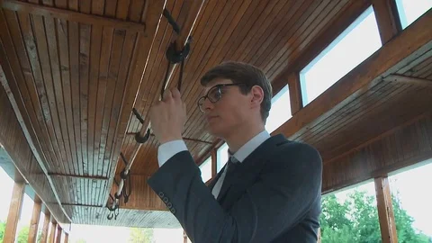 A young man is riding in an old retro streetcar while standing holding the Stock Footage 79083866