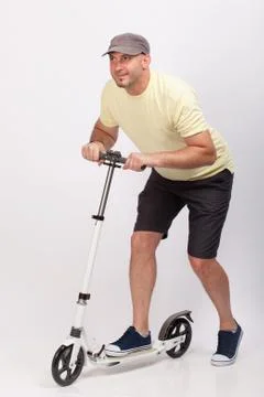 Young man riding a push scooter. Studio shot Stock Photos