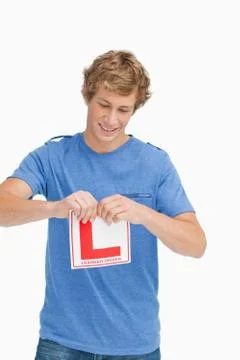 Young man ripping a learner driver sign Stock Photos