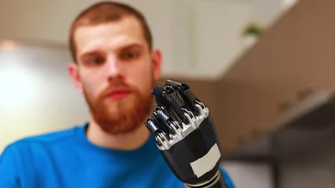 Young man with robotics mechanical modern bionic hand in home Stock Footage 146449684