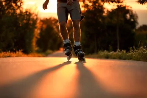 Young man on the roller skates during lovely summer sunset, sport concept 库存照片