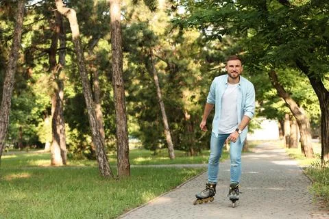 Young man roller skating in summer park. Space for text Fotos de archivo