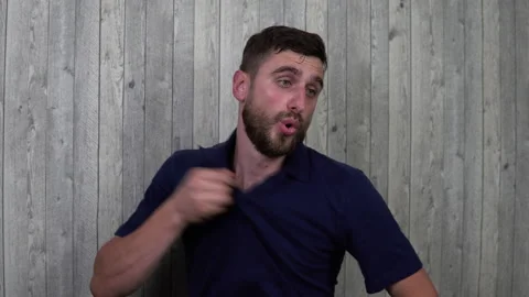 Young man in the room avoiding the heat. Wipes sweat with her hands, feels bad Stock Footage 135663764