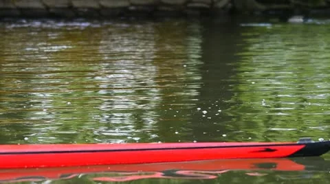 Young man rowing a red boat Stock Footage 11077003