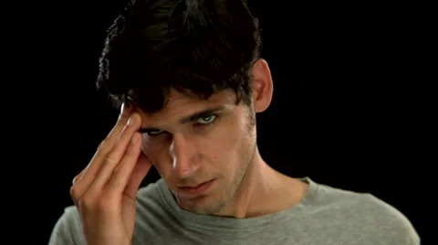 A young man rubs his face Stock Footage 33830155