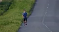 The young man run on the highway. Real time capture. Super telephoto lens shot 4k or 4k+ Resolution