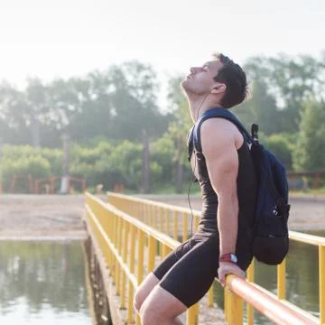 Young man runner resting after workout session on sunny morning Stock Photos