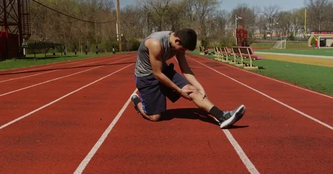 Young man runner stretching at starting line 02 Stock Footage 84130311
