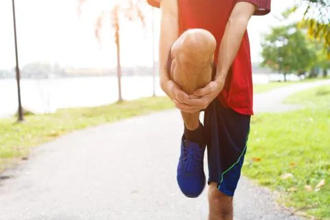 Young man runner warm up before run - workout concept Stock Photos
