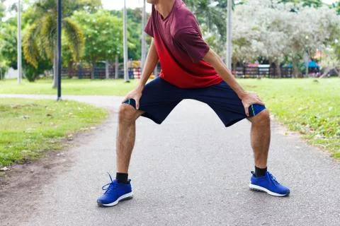 Young man runner warm up before run - workout concept Stock Photos