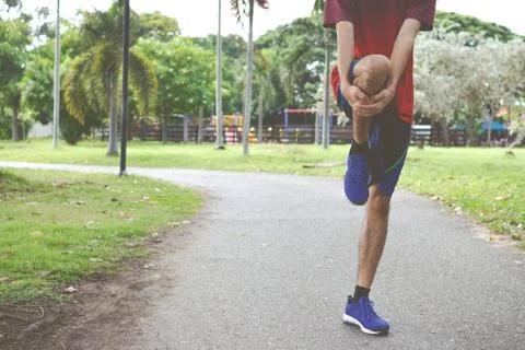 Young man runner warm up before run - workout concept Stock Photos