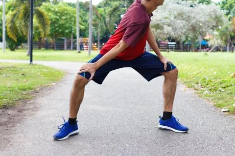 Young man runner warm up before run - workout concept Stock Photos